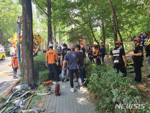 [서울=뉴시스] 류인선 기자 = 17일 오전 서울 도곡동 한 도로에서 빗물받이 설치 작업을 하다 맨홀 아래로 추락한 인부와 이 인부를 구하러 내려간 포크레인 기사가 모두 사망하는 사고가 발생했다. 사진은 소방당국이 인부와 포크레인 기사 구조 작업을 벌이는 모습. 2020.06.17. ryu@newsis.com