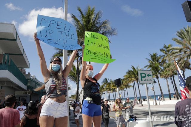 [포트 러더데일(미 플로리다주)=AP/뉴시스]미 플로리다주 포트 러더데일에서 지난 16일 열린 '일할 권리'9Right to Work) 집회에서 바텐더로 일하는 2명의 여성이 '해변을 재개하라'고 쓰인 표지판을 들고 있다. 플로리다와 사우스 캐롤라이나, 조지아, 텍사스 등 가장 먼저 경제 활동을 재개한 미국 남부의 주들에서 젊은 층의 신종 코로나바이러스 감염증(코로나19) 감염이 크게 증가하고 있다고 이들 주 관리들이 경고했다고 CNN이 21일 보도했다. 2020.6.22