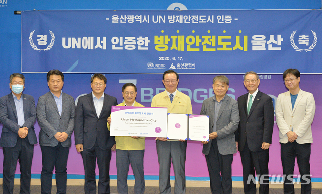 [울산=뉴시스] 배병수 기자 = 울산시는 지난 11일 유엔재난위험경감사무국(UNDRR)으로부터 ‘방재안전도시(Role Model City) 인증’을 받아 17일 오후 시청 프레스센터에서 김윤일(왼쪽 네번째)시민안전실장이 송철호(오른쪽 네번쩨) 시장에게 인증서를 전달받아 관계자들과 함께 기념촬영을 하고 있다. ‘방재안전도시 인증’은 ‘재난에 강한 도시 만들기(MCR, Macking City Resilient)’ 캠페인에 가입된 도시 중 재난 위험을 감소시키고 재난 복원력에 있어 모범이 되는 도시를 유엔재난경감사무국에서 인정해주는 제도이다. 2020.06.17. bbs@newsis.com