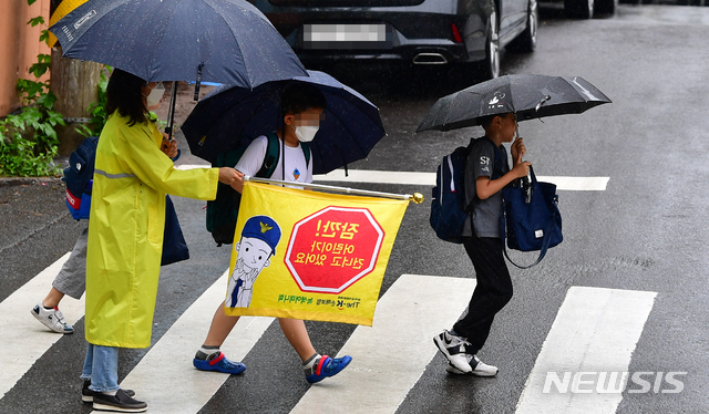 [광주=뉴시스] 류형근 기자 = 비가 내린 지난 18일 오전 광주 남구 봉선동 한 초등학교 앞에서 어린이들이 우산을 쓰고 등교를 하고 있다. 2020.06.18. hgryu77@newsis.com