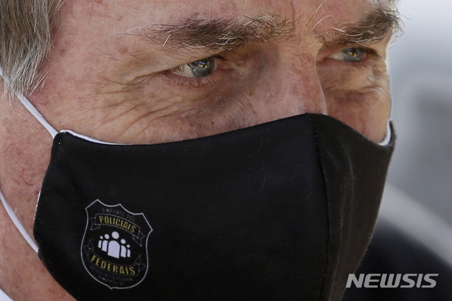 [브라질리아=AP/뉴시스] 자이르 보우소나루(65) 브라질 대통령이 신종 코로나바이러스 감염증(코로나19)에 걸렸다고 7일(현지시간) 발표했다. 그는 자신의 검사 결과를 밝히며 "이게 인생이다. 공포에 떨 이유가 없다"고 말하기도 했다. 사진은 지난 5월 마스크를 착용하고 공식석상에 나선 보우소나루 대통령의 모습. 2020.7.8.