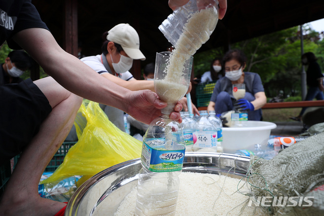 [서울=뉴시스] 전신 기자 = 탈북단체 '큰샘' 회원들이 18일 서울 강남구 일원동 일대에서 북한에 보낼 쌀을 페트병에 담고 있다. 이들은 오는 21일 강화 석모도에서 페트병에 쌀과 마스크를 담아 북한에 보낼 예정이다. 2020.06.18.&nbsp; photo1006@newsis.com