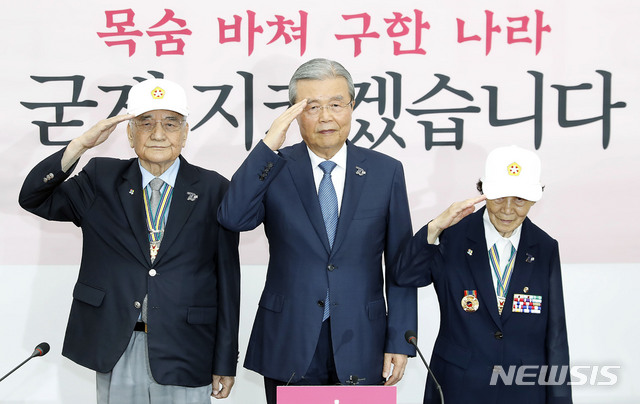 [서울=뉴시스] 최동준 기자 = 김종인 미래통합당 비상대책위원장이 22일 서울 여의도 국회에서 열린 비상대책위원회의에서 6.25 참전 유공자 류연갑(왼쪽) 대한민국 6·25 참전유공자회기념사업국장, 박옥선 한민국 6·25 참전유공자회서울지부 종로구지회장에게 6.25 70주년 기념 호국영웅 배지를 달아준 뒤 거수경례를 하고 있다. 2020.06.22. photocdj@newsis.com