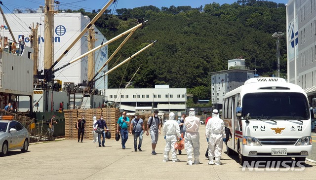 [부산=뉴시스] 부산 감천항에 입항한 러시아 국적 냉동화물선 A호(3933t)의 선원 21명 중 16명이 신종 코로나바이러스 감염증(코로나19) 확진 판정을 받은 가운데 23일 오후 부산의료원으로 이송되는 확진 선원들이 A호에서 하선해 부산소방재난본부의 차량에 탑승하고 있다. (사진=부산소방재난본부 제공). 2020.06.23.  photo@newsis.com