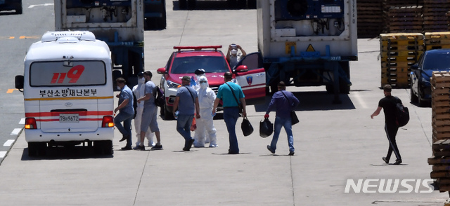 [부산=뉴시스] 하경민 기자 = 부산 감천항에 입항한 러시아 국적 냉동화물선 A호(3933t)의 선원 21명 중 16명이 신종 코로나바이러스 감염증(코로나19) 확진 판정을 받은 가운데 23일 오후 부산의료원으로 이송되는 확진 선원들이 A호에서 하선해 부산소방재난본부의 차량에 탑승하고 있다. 2020.06.23. yulnetphoto@newsis.com