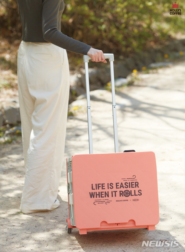 [서울=뉴시스] 24일 유통업계에 따르면 커피전문점 할리스커피는 캠핑이나 피크닉에 유용한 '멀티 폴딩카트'를 출시했다. 핑크빛 외관에 뚜껑까지 포함돼 언제 어디서고 쉽게 펼치고 접어 테이블로 사용할 수 있다. (사진=할리스커피 제공)