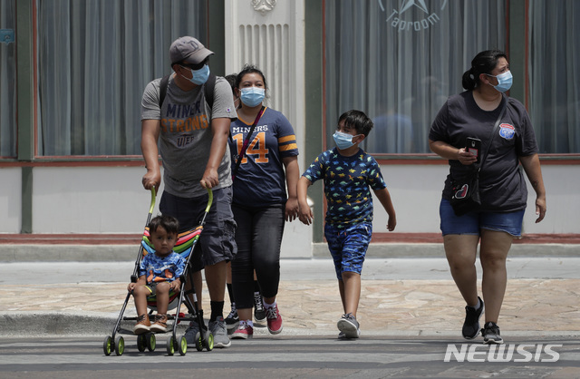 [샌안토니오=AP/뉴시스]24일(현지시간) 미 텍사스주 샌안토니오에서 신종 코로나바이러스 감염증(코로나19) 예방을 위해 마스크를 착용한 한 가족이 거리를 건너고 있다. 텍사스주에서 코로나19 확진 사례가 늘어나면서 그레그 애벗 텍사스 주지사는 사람들에게 공공장소에서는 마스크를 착용하고 가능하면 집에 머물라고 권장하고 있다. 2020.06.25.