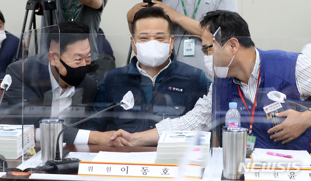 [세종=뉴시스]강종민 기자 = 25일 오후 정부세종청사에서 열린 최저임금위원회 2차 전원회의에서 사용자 위원인 유기정 위원과 근로자 위원인 윤택근 위원(민주노총)이 악수하고 있다. 가운데는 이동호 위원(한국노총). 2020.06.25. ppkjm@newsis.com