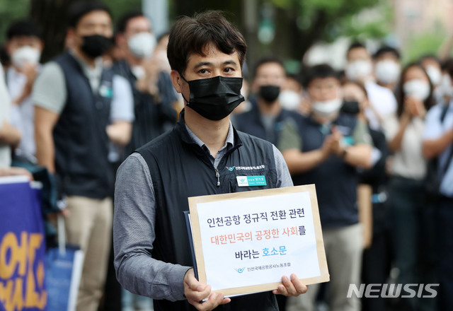 [서울=뉴시스] 박미소 기자 = 장기호 인천국제공항공사 노동조합 위원장이 25일 오후 서울 종로구 청와대 인근에서 열린 기자회견을 마친 후 노조원들의 응원을 받으며 청와대에 제출할 호소문을 들고 이동하고 있다. 인천국제공항공사 노조는 최근 인천공항공사의 일방적이고 기습적인 직고용 발표에 대해 비판하며 공정한 절차가 필요하다고주장했다. 2020.06.27. misocamera@newsis.com