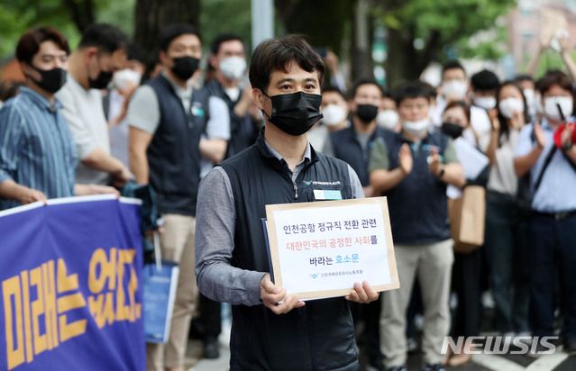 [서울=뉴시스] 박미소 기자 = 장기호 인천국제공항공사 노동조합 위원장이 25일 오후 서울 종로구 청와대 인근에서 열린 기자회견을 마친 후 노조원들의 응원을 받으며 청와대에 제출할 호소문을 들고 이동하고 있다. 인천국제공항공사 노조는 최근 인천공항공사의 일방적이고 기습적인 직고용 발표에 대해 비판하며 공정한 절차가 필요하다고주장했다. 2020.06.25. misocamera@newsis.com