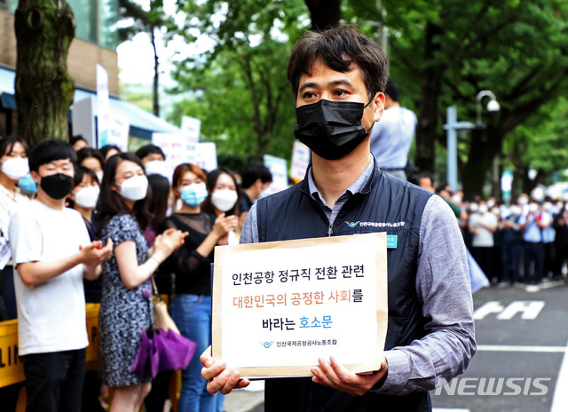 [서울=뉴시스] 박미소 기자 = 장기호 인천국제공항공사 노동조합 위원장이 25일 오후 서울 종로구 청와대 인근에서 열린 기자회견을 마친 후 노조원들의 응원을 받으며 청와대에 제출할 호소문을 들고 이동하고 있다. 인천국제공항공사 노조는 최근 인천공항공사의 일방적이고 기습적인 직고용 발표에 대해 비판하며 공정한 절차가 필요하다고주장했다. 2020.06.25.&nbsp; misocamera@newsis.com