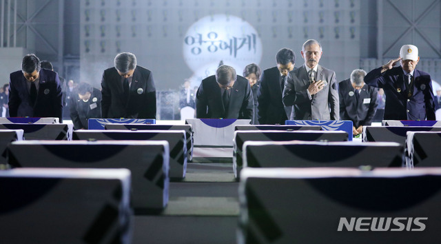 [성남=뉴시스]배훈식 기자 = 문재인 대통령을 비롯한 참석자들이 25일 경기 성남시 서울공항에서 열린 6·25전쟁 제70주년 행사에 참석해 국군전사자 유해함에 6.25참전 기장을 수여한 후 묵념하고있다. 왼쪽부터 정경두 국방부장관, 박삼득 국가보훈처장, 문재인 대통령, 해리 해리스 주한미국대사.2020.06.25. dahora83@newsis.com