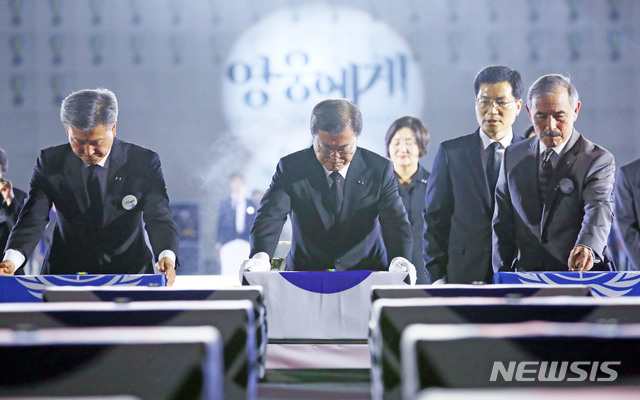 [성남=뉴시스]배훈식 기자 = 문재인 대통령을 비롯한 참석자들이 25일 경기 성남시 서울공항에서 열린 6·25전쟁 제70주년 행사에 참석해 국군전사자 유해함에 6.25참전 기장을 수여하고 있다. 왼쪽부터 박삼득 국가보훈처장, 문재인 대통령, 해리 해리스 주한미국대사.2020.06.25.&nbsp; dahora83@newsis.com 