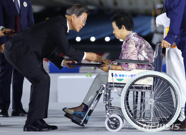 [성남=뉴시스] 배훈식 기자 = 문재인 대통령이 25일 경기 성남시 서울공항에서 열린 6·25전쟁 제70주년 행사에 참석해 고 김명순 이등중사의 유족 유재선씨에게 무궁훈장을 수여하고 있다. 2020.06.25. dahora83@newsis.com