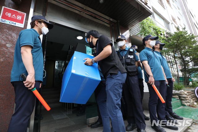 [서울=뉴시스] 조수정 기자 = 대북전단 살포를 해온 탈북민단체 '자유북한운동연합' 박상학 대표와 동생 '큰샘' 박정오 대표의 사무실에 대해 경찰이 압수수색을 한 26일 오후 서울 강남구 일원동 박상학의 '자유북한운동연합' 사무실에 경찰이 압수물품 박스를 들고 들어가고 있다. 2020.06.26. chocrystal@newsis.com