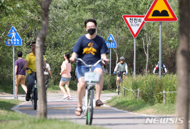 [서울=뉴시스] 고범준 기자 = 휴일인 내륙 대부분에서 30도를 웃도는 무더운 날씨를 보이고 있는 28일 오후 서울 서초구 반포한강시민공원에서 시민들이 자전거를 타고 있다. 2020.06.28. bjko@newsis.com