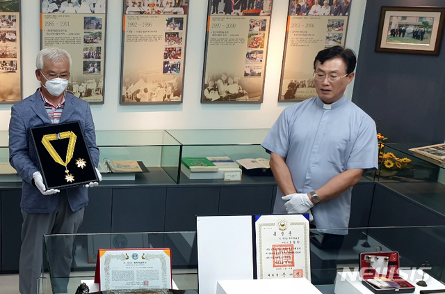 [광주=뉴시스] 변재훈 기자 = 민주화운동에 평생을 바친 고 조비오 신부의 유족들이 28일 광주 남구 소화자매원 역사관에서 최근 추서된 조 신부의 '국민훈장 모란장'을 소장하는 행사를 열었다. 고 조 신부는 지난 10일 6·10 민주항쟁 33주년 기념식을 맞아 한국의 민주화를 앞당기고 인권 신장에 기여한 것으로 평가받아 국민훈장 모란장을 추서됐다. (사진=조영대 신부 제공) 2020.06.28. photo@newsis.com