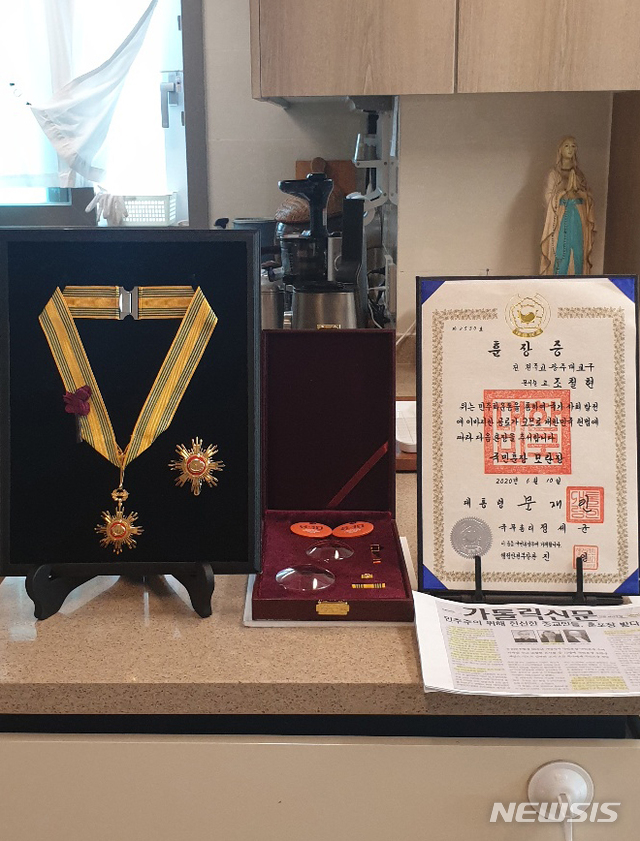 [광주=뉴시스] 변재훈 기자 = 민주화운동에 평생을 바친 고 조비오(조철현) 신부의 유족들이 28일 광주 남구 소화자매원 역사관에서 최근 추서된 조 신부의 '국민훈장 모란장'을 소장하는 행사를 열었다. 고 조 신부는 지난 10일 6·10 민주항쟁 33주년 기념식을 맞아 한국의 민주화를 앞당기고 인권 신장에 기여한 것으로 평가받아 국민훈장 모란장을 추서됐다. 사진은 조비오 신부의 '모란장' 훈장과 훈장증. (사진=조영대 신부 제공) 2020.06.28.photo@newsis.com