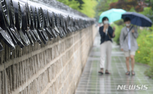 [전주=뉴시스] 김얼 기자 = 전북 전주한옥마을에서 우산을 쓴 관광객들이 발걸음을 재촉하고 있다. 