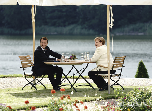 [베를린=AP/뉴시스]에마뉘엘 마크롱 프랑스 대통령(왼쪽)과 앙겔라 메르켈 독일 총리가 29일(현지시간) 독일 베를린 인근의 메제베르크 성에서 만나 회담하고 있다. 2020.6.30.