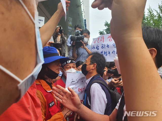 [서울=뉴시스]김진아 기자 = 1일 오전 8시께 서울 정동 전국민주노동조합총연맹(민주노총) 본회 앞. 김명환 민주노총 위원장이 노사정합의 파기를 주장하는 비정규직 노조에 에워쌓여 있다. 2020.07.01. hummingbird@newsis.com 