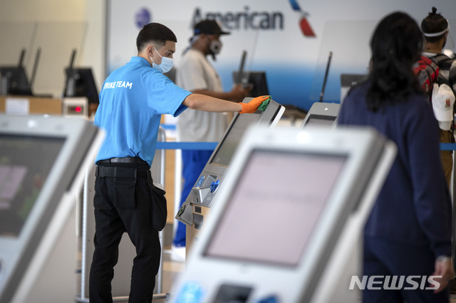 [그레이프바인=AP/뉴시스] 6월30일(현지시간) 미국 텍사스주 그레이프바인에 위치한 댈러스 포트워스 국제공항에서 직원들이 아메리칸 항공 체크인 키오스크(무인기기)를 닦고 있다. 2020.07.03. 
