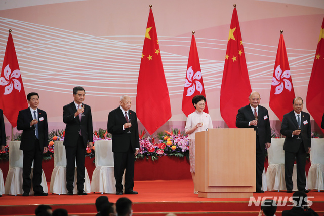 [홍콩=AP/뉴시스] 1일 홍콩 완차이 컨벤션센터 앞 골든 보히니아 광장에서 홍콩 반환 23주년 기념행사가 열린 가운데 캐리 람 행정장관과 참석자들이 건배를 하기 위해 잔을 들고 있다. 2020.07.01 