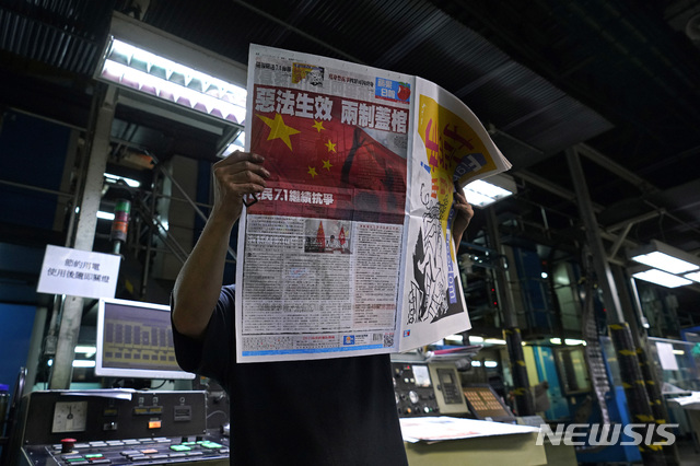 [홍콩=AP/뉴시스]1일(현지시간) 홍콩의 한 신문 인쇄소에서 이곳 직원이 "악법 발효, 일국양제 붕괴"라고 1면을 장식한 빈과일보 판본을 확인하고 있다. 2020.07.03. 