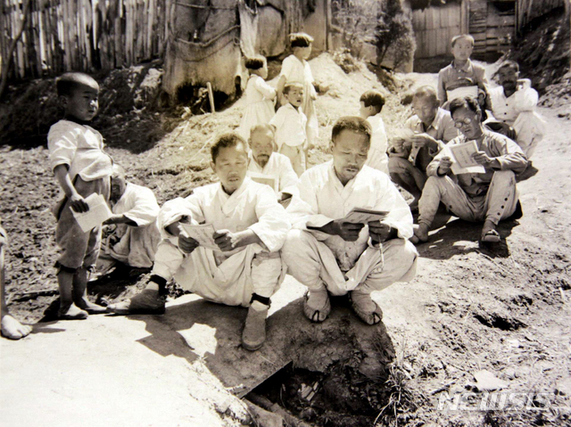 [서울=뉴시스] 1948년 5월 5일 ‘5·10 총선거’를 앞두고 선거 홍보 전단을 읽고 있는 시민들. (사진=미디어한국학 제공) 2020.07.05. photo@newsis.com