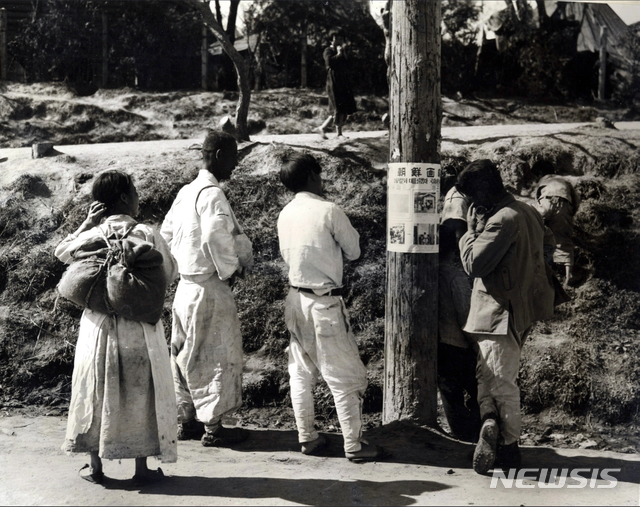 [서울=뉴시스] 총선거를 앞두고 공보부에서 제작해 거리에 붙인 투표 과정을 안내하는 포스터를 시민들이 관심 있게 지켜보고 있다. (사진=미국 국립문서기록청) 2020.07.05. photo@newsis.com (* 위 사진은 재배포, 재판매, DB 및 활용을 금지합니다)