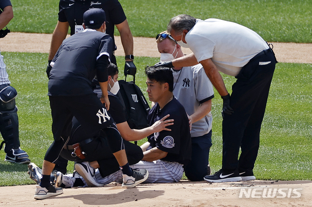 [뉴욕=AP/뉴시스] 메이저리그(MLB) 뉴욕 양키스의 일본인 투수 다나카 마사히로가 5일(한국시간) 미국 뉴욕주 브롱스의 양키스타디움에서 진행된 팀 훈련에서 지안카를로 스탠튼의 타구에 맞은 후 트레이너에게 응급처치를 받고 있다. 2020.07.05