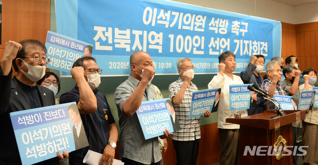 [전주=뉴시스] 김얼 기자 = 이석기 의원 내란 음모사건 피해자 전북규명위원회 관계자들이 6일 전주시 전북도의회 브리핑룸에서 '이석기 의원 석방을 촉구하는 전북지역 각계인사 100인 선언' 기자회견을 열고 구호를 외치고 있다. 2020.07.06. pmkeul@newsis.com