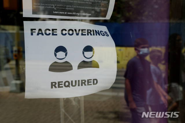 [샌안토니오=AP/뉴시스] 7일(현지시간) 신종 코로나바이러스 감염증(코로나19) 확진자가 급증하고 있는 미국 텍사스주 샌안토니오에서 마스크를 쓴 행인이 마스크 착용을 요청하는 안내문 앞을 지나고 있다. 2020.07.09. 