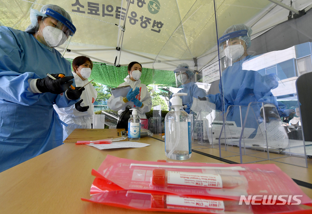 [광주=뉴시스] 신대희 기자 = 8일 광주 광산구 보건소 코로나19 선별진료소에서 의료진이 문진과 검체 채취 관련 논의를 하고 있다. 2020.07.08.sdhdream@newsis.com