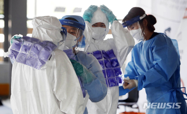 [광주=뉴시스] 신대희 기자 = 8일 광주 북구보건소 효죽공영주차장 코로나19 선별진료소에서 의료진들이 더위를 이겨내기 위해 서로에게 냉조끼를 입혀주고 있다. (사진 = 광주 북구 제공) 2020.07.08. photo@newsis.com