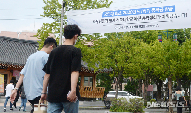 [전주=뉴시스] 김얼 기자 = 신종 코로나바이러스 감염증(코로나19)의 여파로 인해 전국의 대학이 등록금 반환의 문제와 더불어 환급에 대한 요구가 이어지고 있는 9일 전북 전주시 전북대학교 구 정문 입구에 '국립대 최초 2020년도 1학기 등록금 환불'을 알리는 현수막이 붙어 있다.   전북대학교는 신종 코로나바이러스 감염증(코로나19)의 여파로 학교에 나오지 못한 대학생들의 학습권을 위해 국립대학교 중 처음으로 등록금 환불을 결정했다. 2020.07.09. pmkeul@newsis.com