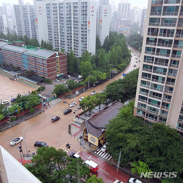 [부산=뉴시스] 부산지역에 호우경보가 발효된 10일 해운대구 좌동 일대의 도로가 침수돼 차량들이 힘겹게 이동하고 있다. (사진=부산경찰청 제공). 2020.07.10.&nbsp;&nbsp;&nbsp; photo@newsis.com 