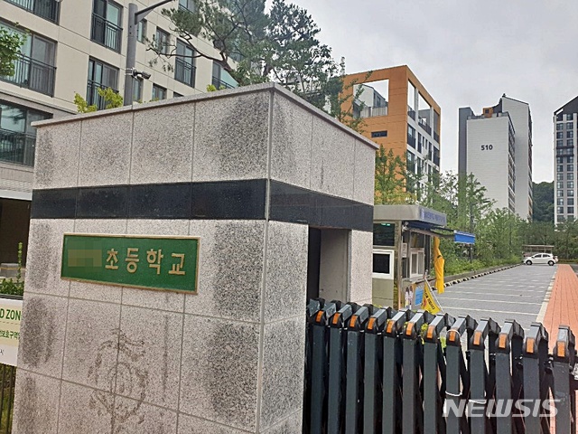 [세종=뉴시스] 해당 초등학교를 뒤편으로 임대아파트와 같은 학군에 포함됐다며, 철회해 줄것을 요구하는 아파트 단지가 보인다.