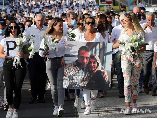 [바욘(프랑스)= AP/뉴시스] 프랑스 남서부도시 바욘에서 코로나19 방역 수칙에 따라 승객들에게 마스크착용을 권하다가 몰매를 맞아 숨진 필립 몽기요씨의 아내 베로니크(가운데)가 8일 남편의 사진을 들고 시위대와 함께 엄정한 처벌을 요구하고 있다.&nbsp;&nbsp; 