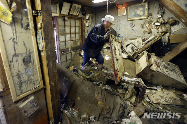 [구마모토=AP/뉴시스]지난 12일 일본 구마모토현 히토요시시 거주하는 한 남성이 침수 피해를 입은 자신의 주택에서 약을 찾고 있다. 2020.07.14.