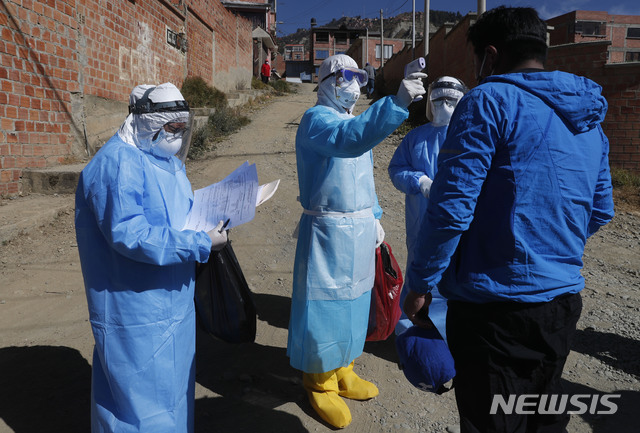 [라파스=AP/뉴시스] 12일(현지시간) 신종 코로나바이러스 감염증(코로나19)이 확산하는 가운데 볼리비아 라파스 외곽에서 보호장비를 착용한 의사가 집마다 방문해 체온을 재고 있다. 2020.07.13.