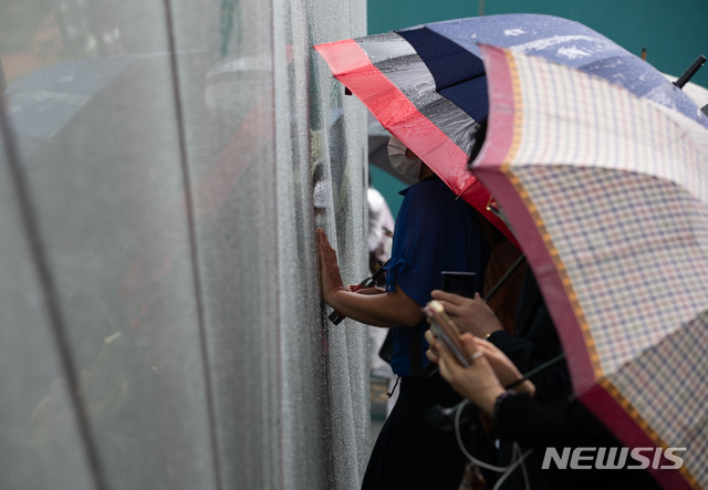 [서울=뉴시스]고승민 기자 = 13일 서울시청에서 박원순 서울시장의 영결식이 열린 가운데 그를 추모하는 시민들이 시청사 유리벽을 지켜보고 있다. 2020.07.13.photo@newsis.com