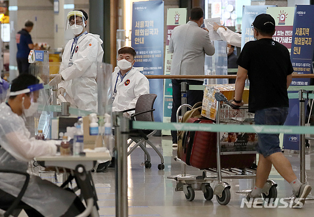 [인천공항=뉴시스] 이영환 기자 = 신종 코로나바이러스 감염증(코로나19) 해외유입 신규 확진자가 증가하고 있는 14일 오전 인천국제공항 제1여객터미널에서 입국한 승객들이 안내를 받고 있다. 중앙방역대책본부는 14일 0시 기준으로 신규 확진자가 33명 늘었으며 이중 해외유입이 19명, 지역 발생 14명이라고 밝혔다. 2020.07.14. 20hwan@newsis.com