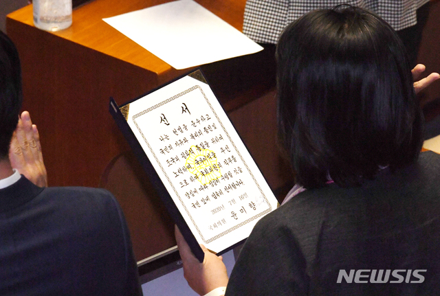 [서울=뉴시스] 김진아 기자 = 제21대 국회 개원식이 열린 16일 서울 여의도 국회 본회의장에서 윤미향 더불어민주당 의원이 국회의원 선서를 하고 있다. 2020.07.16. photo@newsis.com