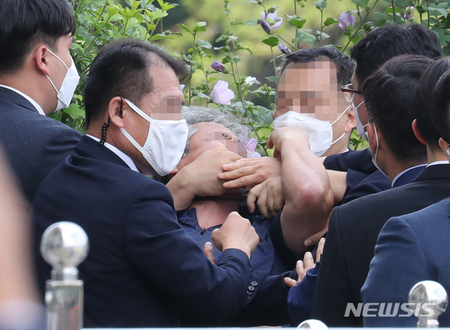 [서울=뉴시스] 김진아 기자 = 16일 오후 정모씨가 서울 여의도 국회 본청 인근 계단 앞에서 21대 국회 개원식을 마치고 돌아가는 문재인 대통령을 향해 "북한인권 무시" 등의 구호를 외치다가 관계자에 의해 제지당하고 있다. 2020.07.16. photo@newsis.com