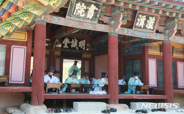 [함양=뉴시스]지난해 7월17일 경남 함양군 수동면 남계서원에서 열린 남계서원 세계유산 등재 1주년 기념 ‘전국 한시 백일장 대회’에서 유복(儒服)을 입은 참가자들이 한시 짓기에 몰두하고 있다. (사진=함양군청 김용만 주무관 제공) 2021.02.05 photo@newsis.com