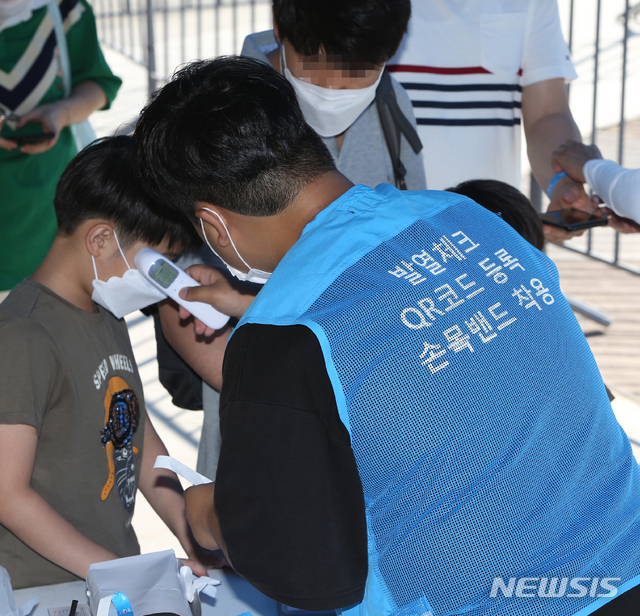 [강릉=뉴시스] 김경목 기자 = 해수욕장 개장 첫날인 17일 오후 방역요원이 강원 강릉시 안현동 경포해수욕장 중앙통로 방역 게이트에서 어린이의 발열 여부를 확인하고 있다. 2020.07.17. photo31＠newsis.com