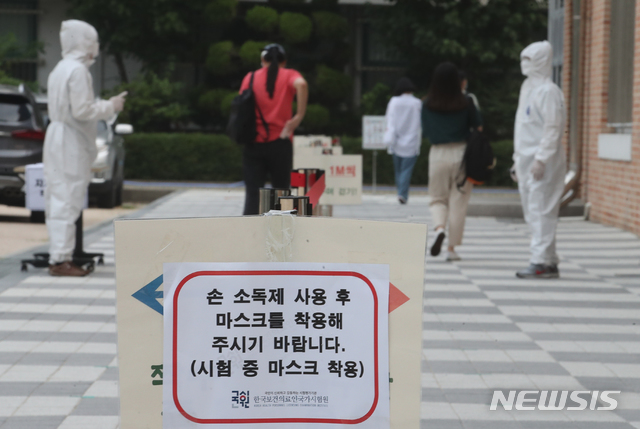 [서울=뉴시스]김명원 기자 = 보건직 공무원 필기시험 18일 오전 서울 송파구 올림픽로 잠실중학교에서 열린 가운데 수험생들이 사회적 거리두기, 손소독 및 발열체크를 받으며 입실하고 있다. 49명을 선발하는 이번 시험은 8월 8일(토) 면접시험에 이어 8월 21일(금)에 최종합격자를 보건복지부 홈페이지에 발표할 예정이다. 다만 모든 일정은 코로나19 상황에 따라 연기(조정)될 수 있다. 2020.07.18. kmx1105@newsis.com