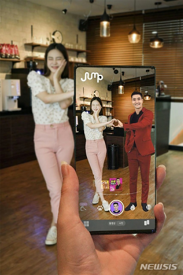 [서울=뉴시스]SK텔레콤 홍보모델이 점프 AR 앱에서 K팝 그룹 슈퍼주니어 멤버 최시원씨 이미지를 소환해 함께 셀카를 찍고 있다. 점프 AR은 K팝 가수, 애완·희귀 동물, LoL(롤) 게임 캐릭터 등 실감나는 움직임과 음향효과를 갖춘 AR 콘텐츠를 제공한다. (사진=SK텔레콤 제공) 2020.07.20