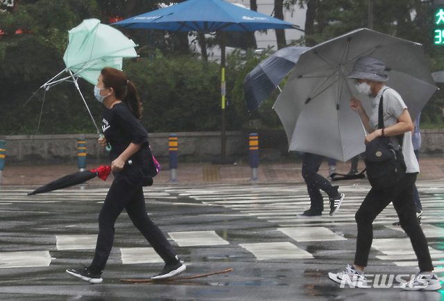 [인천=뉴시스] 이종철 기자 = 강한 바람이 불고 비가 온 지난 달 20일 오전 인천시 미추홀구 인천터미널역 사거리에서 시민들이 바람에 날리는 우산을 잡고 횡단보도를 건너가고 있다. 2020.07.20. jc4321@newsis.com